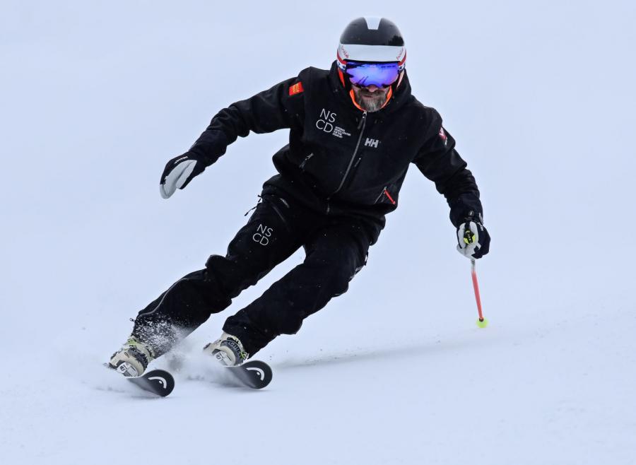 Kyle Moxley skiing down a mountain
