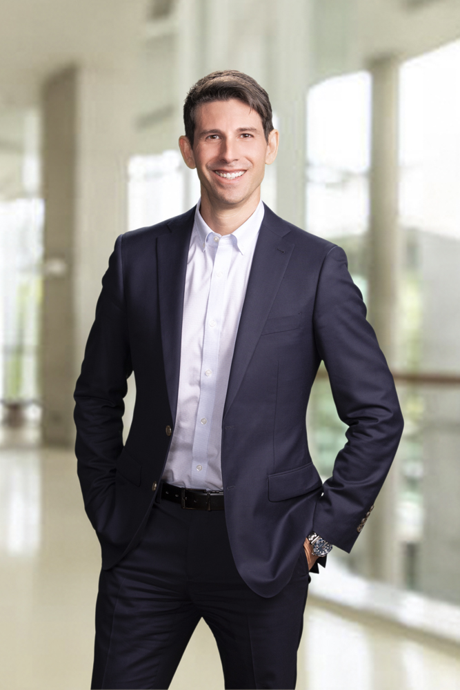 Attorney Jason Revzin of Anthem Injury Lawyers wearing a suit standing in his office