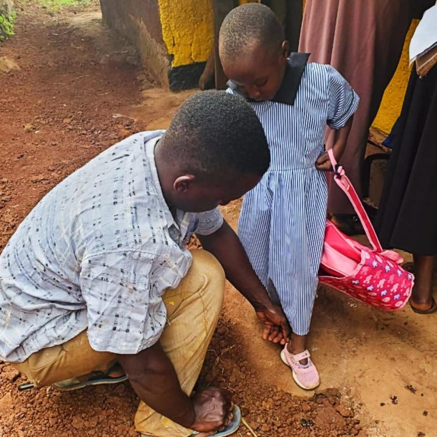 A young girl in Wanga Parish wears her new pink shoes to her first day of school.