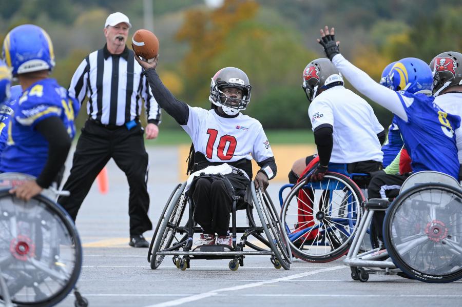 A Tampa Bay wheelchair football player passes the ball during a game against the Los Angeles Rams