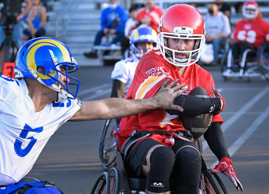 Kansas City Chiefs Wheelchair Football Player fends off a member of the L.A. Rams Wheelchair Football Team