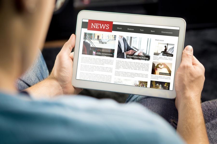 A man views a news site on a tablet