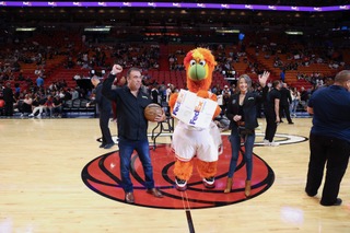 Good Greek Moving and Storage Founder and CEO, Spero Georgedakis, celebrate a Miami HEAT win center court with mascot Burnie