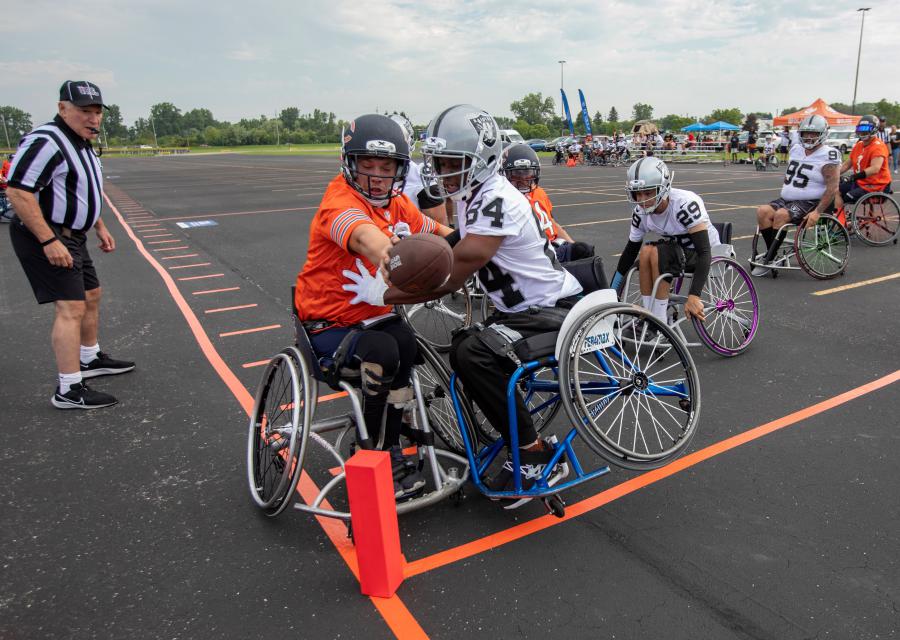 Gabe Denbraber of the GLASA Chicago Bears extends the ball toward the goal line against defender Darnell Calahan of the Las Vegas Raiders during a game