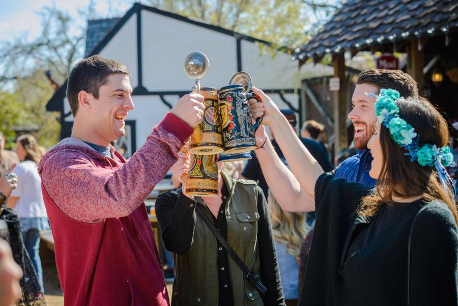 4 people clink beer steins, caption: Texas Renaissance Festival wraps record breaking 2023 season, begins planning for 50th anniversary celebration in 2024.