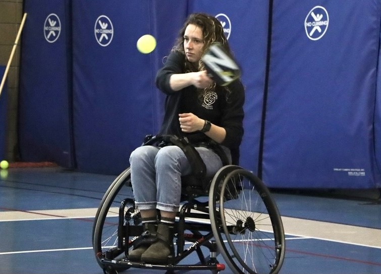 Individual in wheelchair playing pickleball