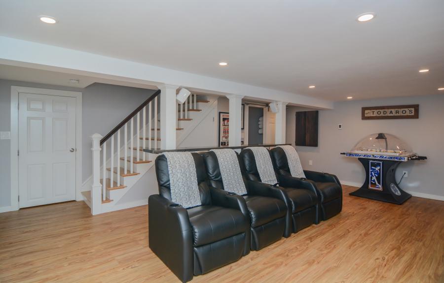 Basement with theatre recliners that are black leather