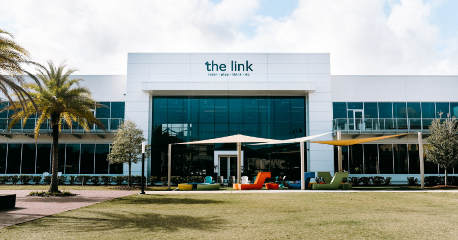Large white building with a sign reading 'The Link' under a clear blue sky.