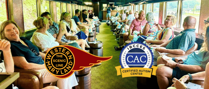 A group of passengers sitting inside a scenic train car, with the Western Maryland Scenic Line and IBCCES Certified Autism Center™ logos prominently displayed.