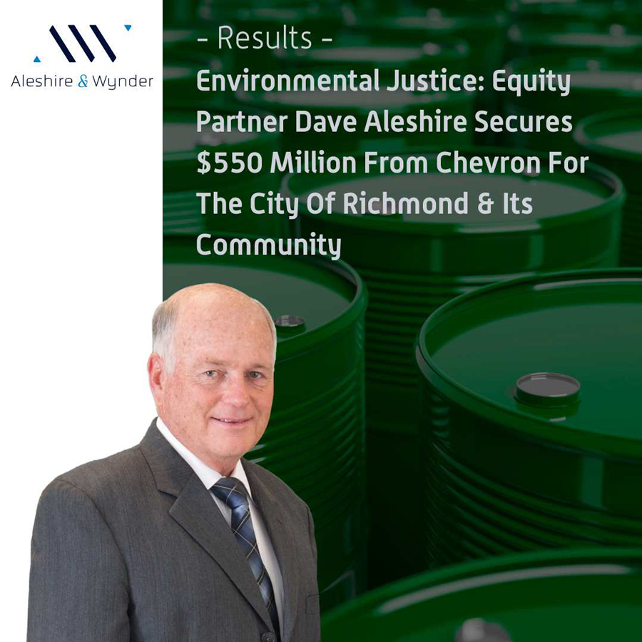 Green oil barrels with City Attorney Dave Aleshire and company logo