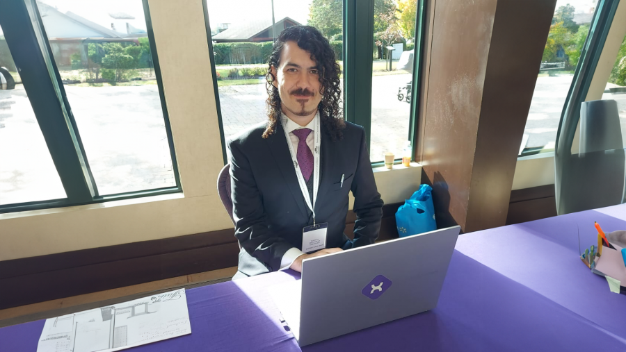 Image of Nawar Kamel, CEO of Experto AI Inc sitting behind his laptop on a purple table