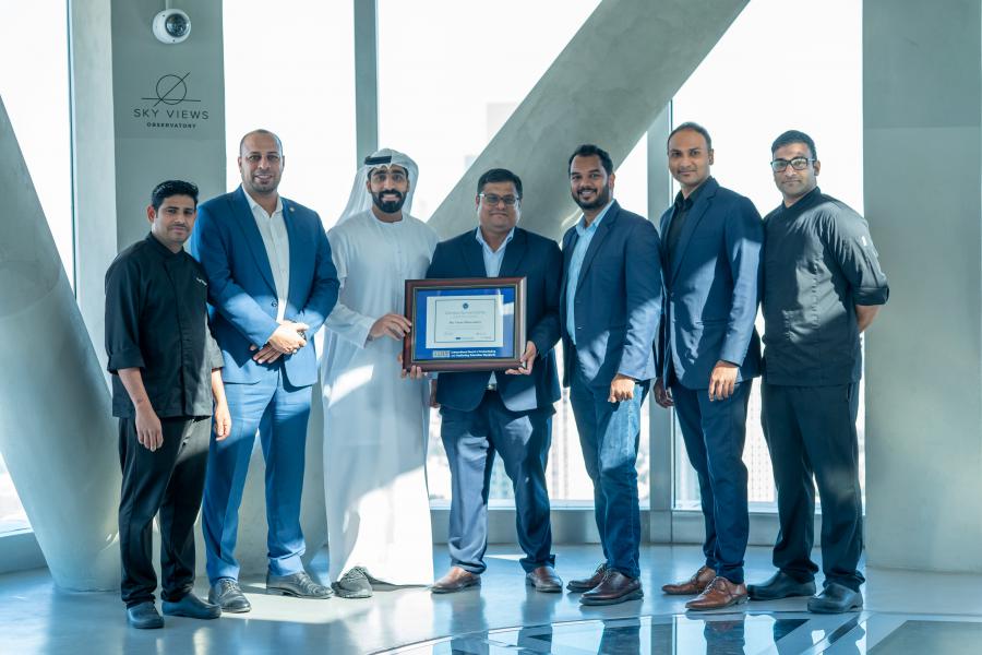 The team from At the Top, Burj Khalifa and IBCCES taking a photo with the framed certificate