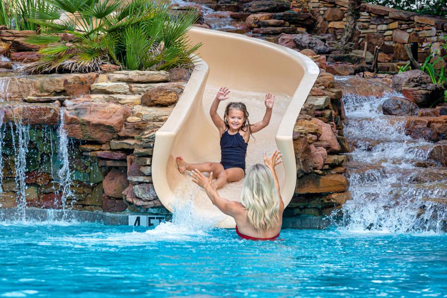 child sliding down pool slide