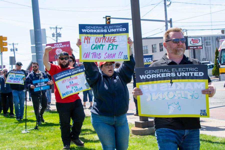 Workers holding signs protesting offshoring and other issues at GE Aerospace