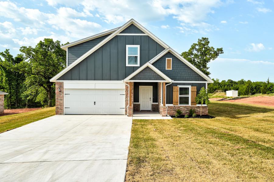 Close-up of front porch and entryway at 201 Stella Trail, a Cape Cod-style home in Buck Crossing with shaker siding, brick trim, and natural wood shutters.
