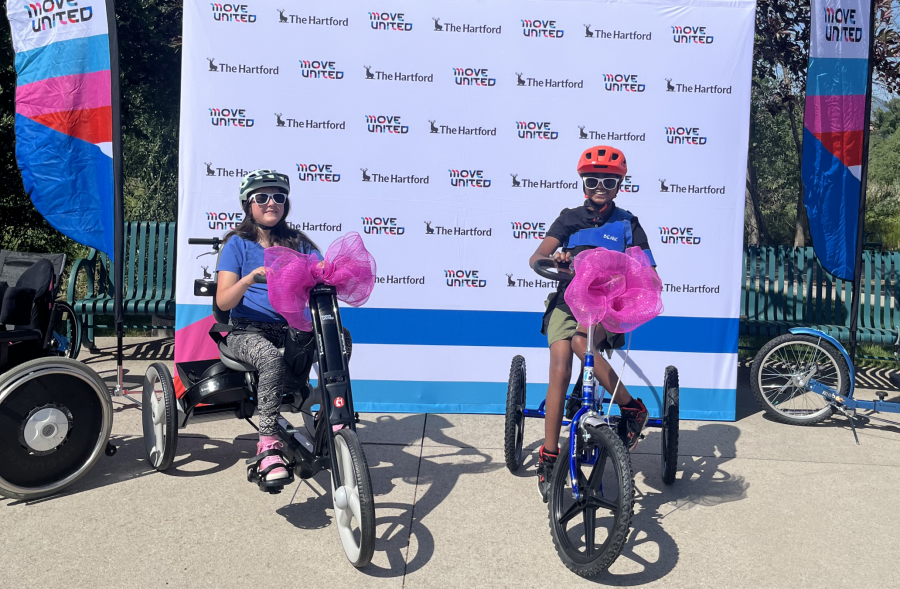 Luci Wilde and Ethan Benjamin sitting on their new adaptive cycles