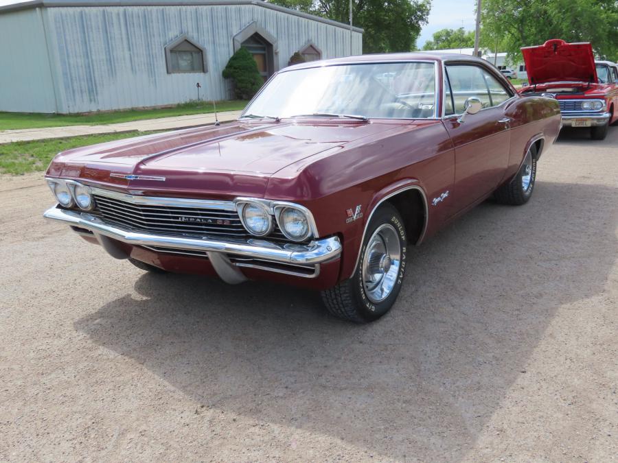 Restored maroon 1965 Chevrolet Impala SS, runs and drives, rally rims, powered by a 396 V8 with 4bbl carb, 4-speed manual transmission with Hurst shifter. Odometer shows 100,995 miles.