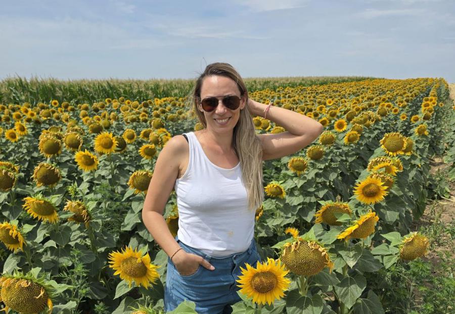 Ana Mitrovic smiling in a field of daisies, representing the freedom and fulfillment of building a successful work-from-home business as a mom using modern tools and AI.