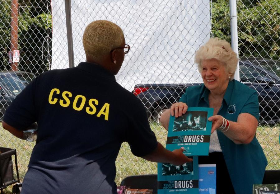 Attendee learning about the Drug-Free World program from Rev. Susan Taylor