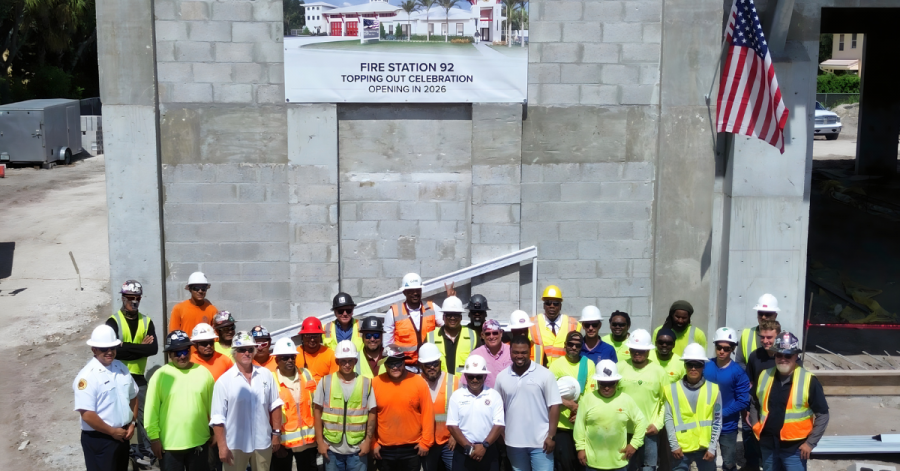 Group photo of construction crew, county officials, and fire rescue personnel in hard hats and safety vests at the Fire Station 92 site in Lake Worth during the topping-out celebration.