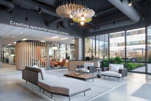 PeopleSpace San Jose Customer Experience Center featuring their lobby space with lounge seating, custom reception desk, acoustical lighting pendants and views into the Pergola meeting space