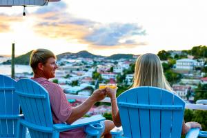 Couple enjoying sunset drinks overlooking Charlotte Amalie Harbor from a boutique hotel in St. Thomas