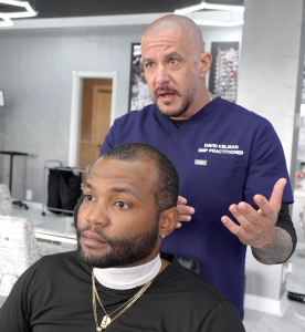 David Kelman, owner of SMP INK CDA, talking to adult male about Scalp Micropigmentation Services