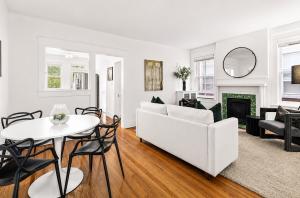 Professionally staged living and dining room designed by Jsquared Interior Staging & Design with contemporary furnishings, hardwood floors, original historic  fireplace, and abundant natural light.