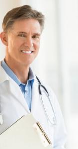 Male doctor holding clipboard smiling