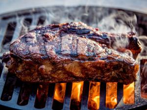 A Steak With Grill Marks on a Carbon Steel Grate