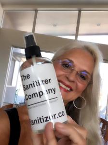 The Sanitizer Company's Anna Miller holding a bottle of Toprosan™ 75% ethyl alcohol liquid sanitizer.  It kills COVID 19