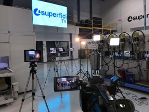 Photograph shows interior of Superfici America's technology center featuring the lights and production cameras for Superfici TV.