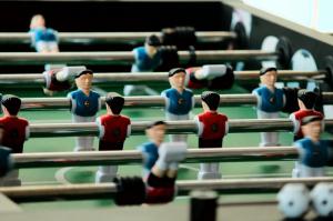 Red and blue teams oppose each other on a foosball table