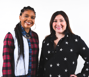 two women smiling in front of a white background