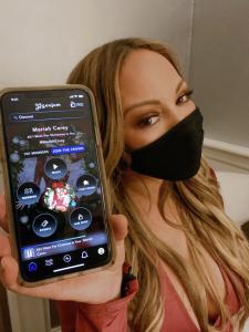 Mariah Carey wearing facemask and holding cellphone that reads Geojam