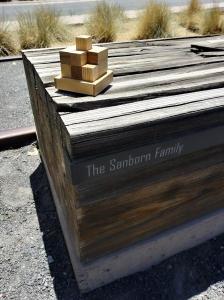 The Sanborn Family bench in Railyard Park, Santa Fe. The tiny angel wings charm was hidden in a crevasse at the end of the bench.