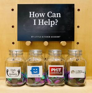How Can I Help by Little Kitchen Academy sign on chalkboard with 4 glass jars and logos of Chefs for Humanity, PHIT America, Global FoodBanking Network, Kids Help Phone