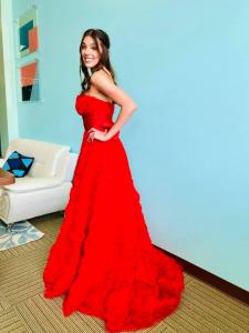 Beautiful dark haired high-school senior in red formal prom dress.