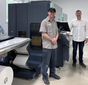 Josh Odom (left), Digital Production Manager, stands with Paul Thompson (right), VP and GM of General Data's AmeriGraph division next to the new HP Indigo 6900 digital press in General Data’s AmeriGraph Atlanta facility