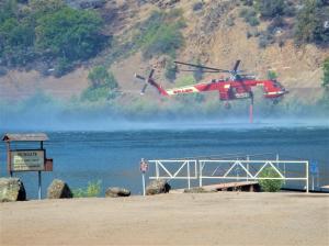 Firefighting helicopter draws water from Iron Gate Lake on the Klamath River to fight the Klamathon Wildfire