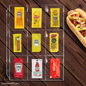 A binder page with several pockets holds mustard and ketchup packets. The binder page lies on a table next to a hot dog.