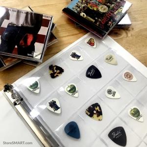 A clear plastic binder page with several pockets, filled with guitar picks.