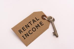 'Rental Income' written on a tag attached to a key with a white background