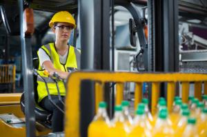 Picture of a female driving a forklift in a warehouse setting