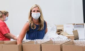 Blonde woman packing boxes for the local food bank.