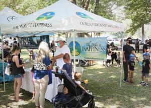 In this shot People are gathering around The Way To Happiness table getting free information in William Land Park