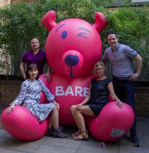 4 BARE co-founders sit on blow up bear, the BARE mascot