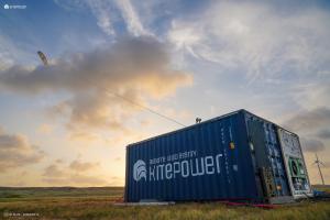Kitepower containerised wind energy system and battery in a field on Aruba