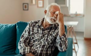 A man sits back on a couch and rubs his eyes.  People can get help to meet Social Security's strict definition of: "incompetence" from disability attorneys such as Geary Disability Law in Wisconsin.