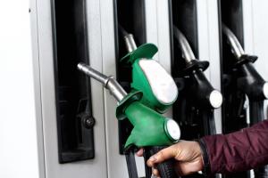 Person lifting fuel pump to refuel car